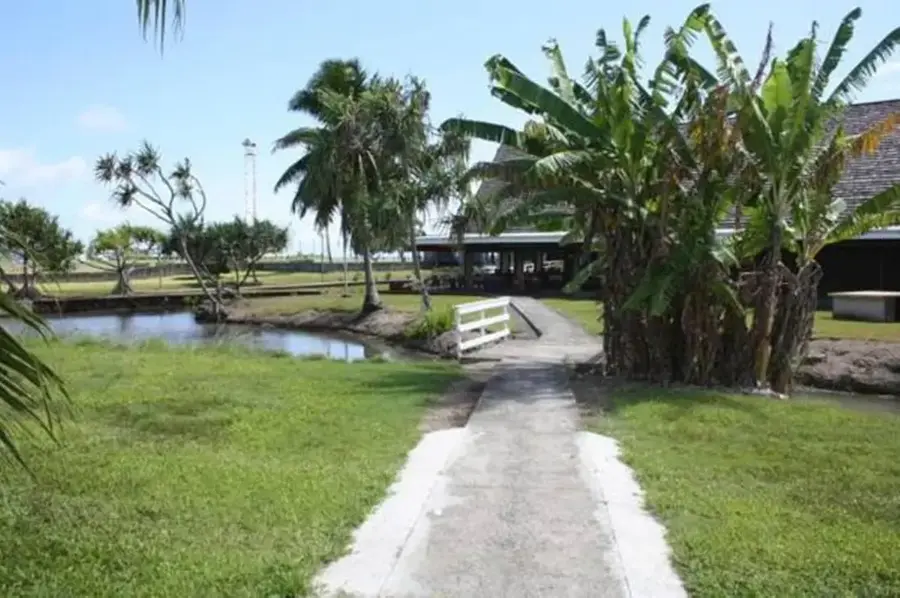 Jardin et allée menant aux bungalows de Raiatea Airport Bungalow