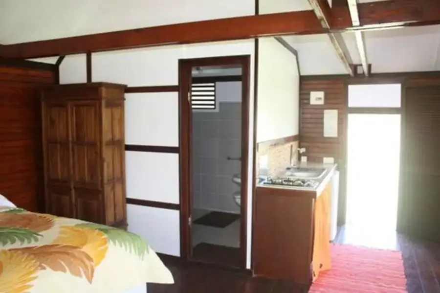 Chambre du bungalow studio avec lit double et murs en bois